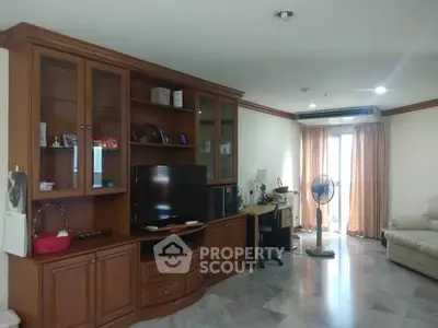 Spacious living room with wooden entertainment center and natural light