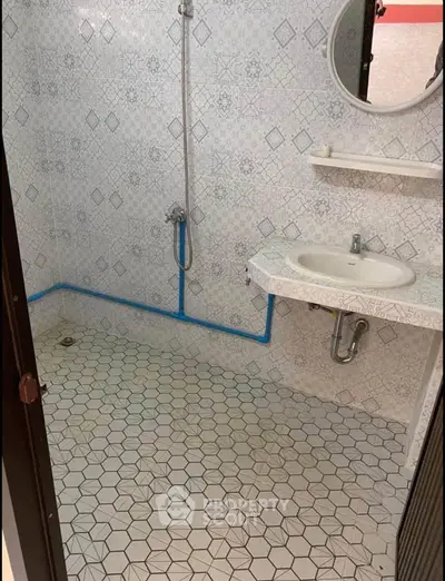 Spacious bathroom with geometric tile design and modern fixtures
