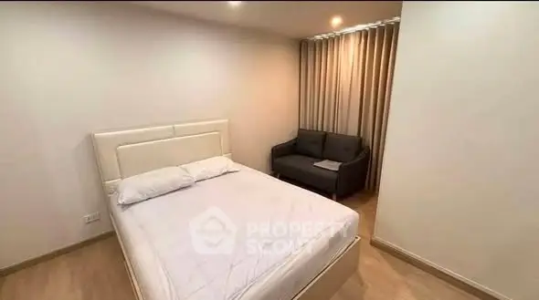 Spacious bedroom with modern decor and cozy seating area, perfect for relaxation.
