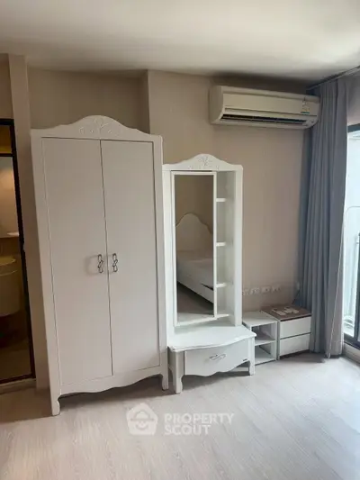 Charming bedroom with elegant white furniture and natural light, perfect for a cozy and stylish living space.