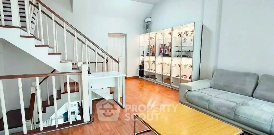 Spacious living room with modern staircase and display cabinets