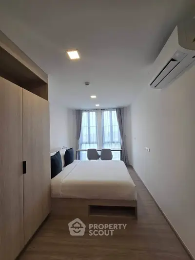 Modern bedroom with large window and minimalist design in a stylish apartment.