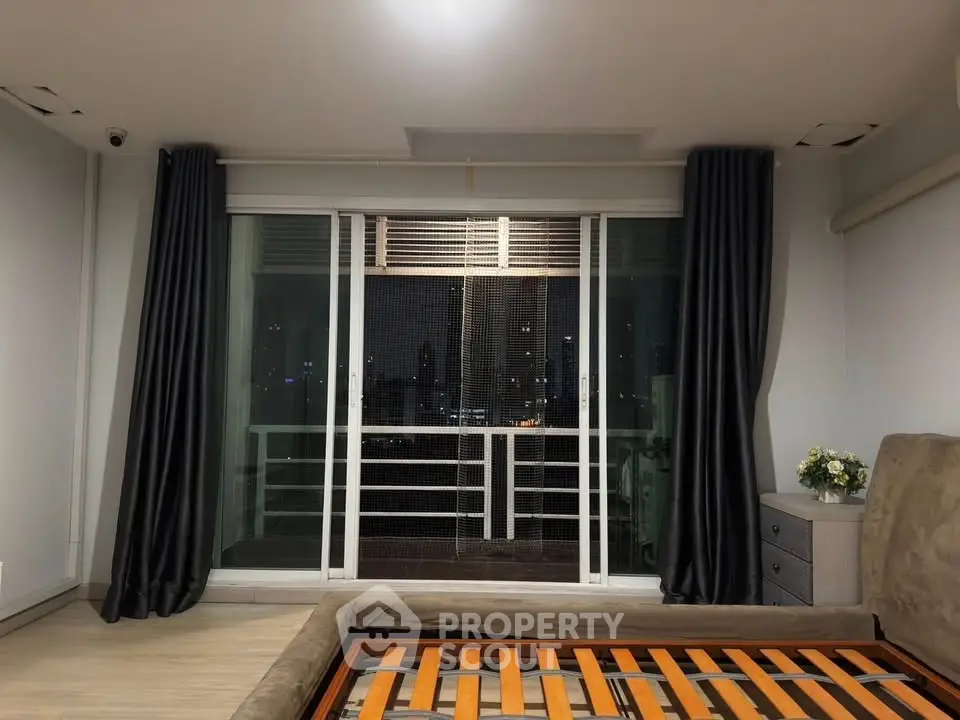 Spacious bedroom with city view and large windows, perfect for urban living.