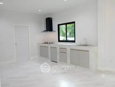 Modern kitchen with sleek cabinetry and gas stove in a bright, minimalist design.