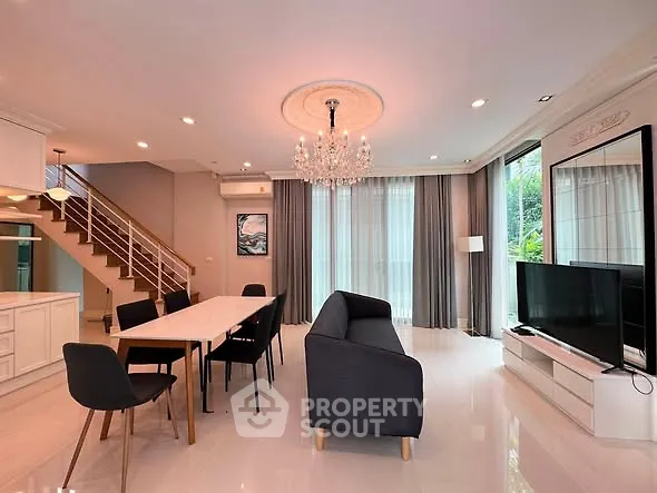 Luxurious open-plan living room with elegant chandelier and modern furnishings