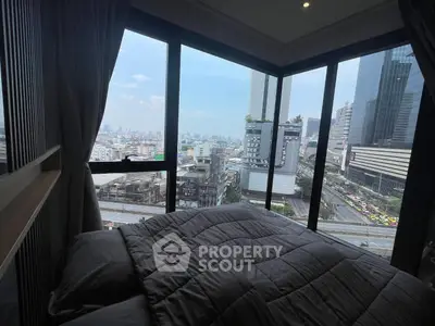Luxurious bedroom with panoramic city view from floor-to-ceiling windows in a high-rise building.