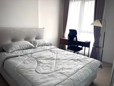 Modern bedroom with cozy bed and study desk by the window