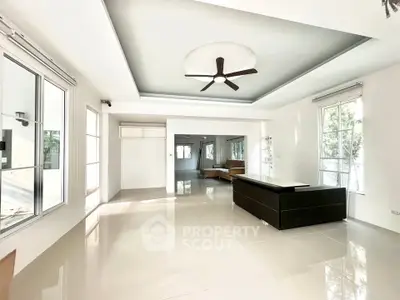 Spacious modern living room with ceiling fan and large windows