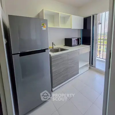 Modern kitchen with sleek appliances and open layout, featuring a spacious fridge and microwave.