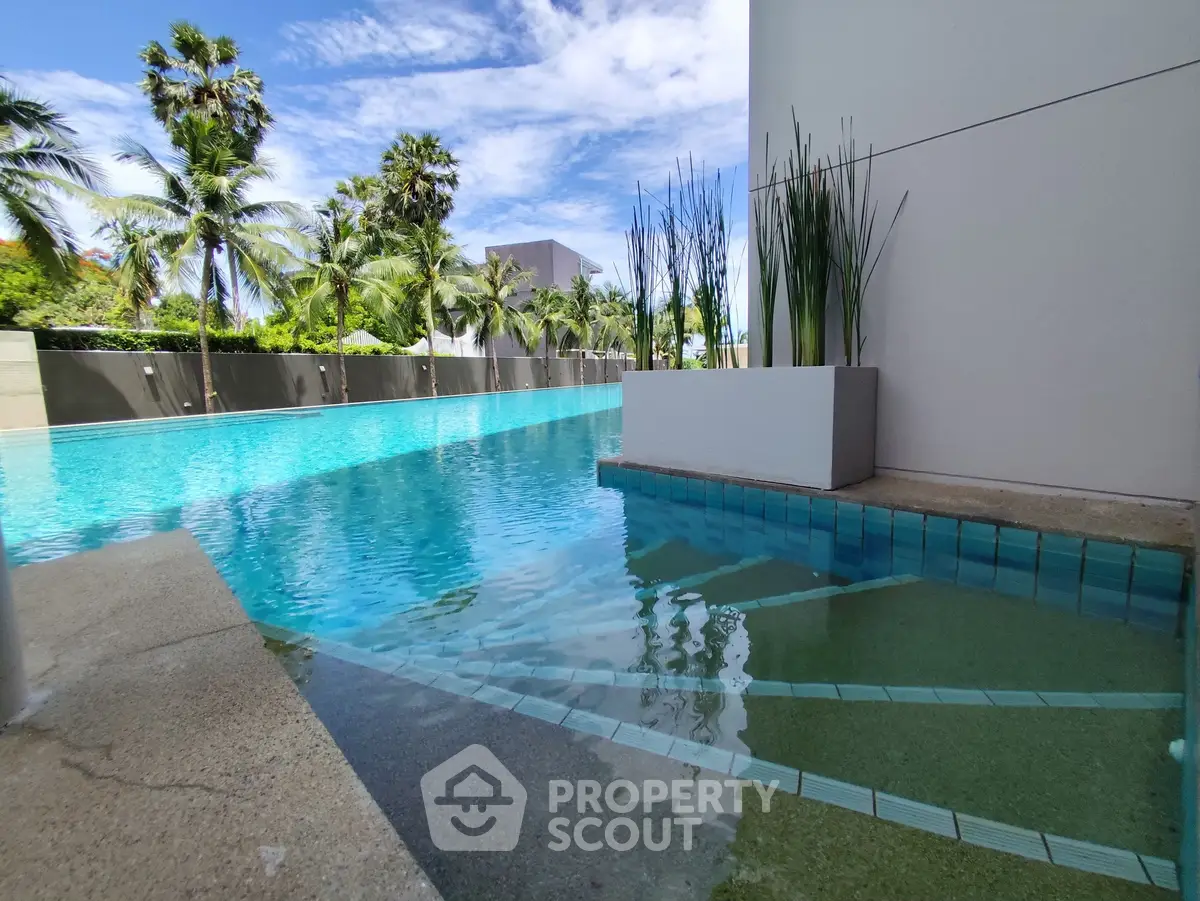 Luxurious poolside view with palm trees and modern architecture
