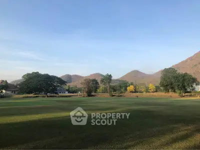 Scenic view of expansive green field with mountains in the background, perfect for serene living.