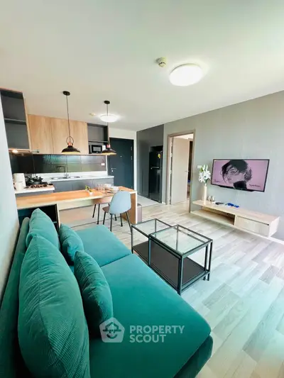 Modern open-layout living room with stylish kitchen and cozy seating area.