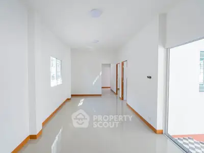 Spacious and bright empty room with glossy tiled floors and large windows, perfect for customization.