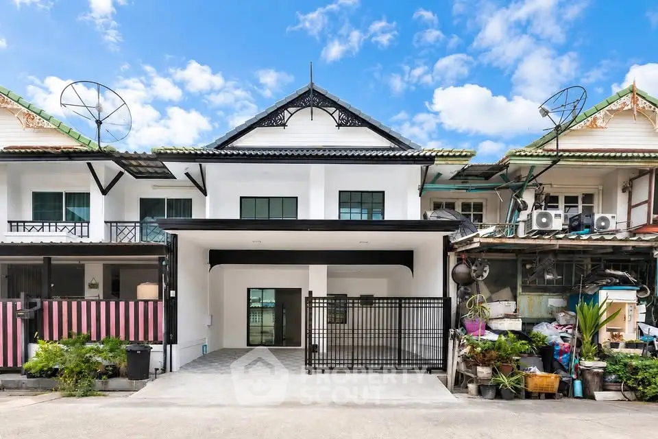 Charming townhouse with gated entrance and satellite dishes, perfect for modern living.