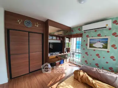 Charming bedroom with modern decor and natural light, featuring a stylish wardrobe and cozy ambiance.