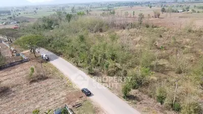 Scenic aerial view of rural land with road access and lush greenery, ideal for development.