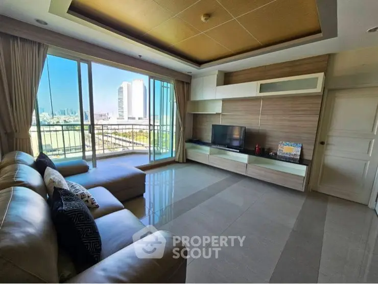 Spacious living room with modern decor and city view, featuring large windows and comfortable seating.