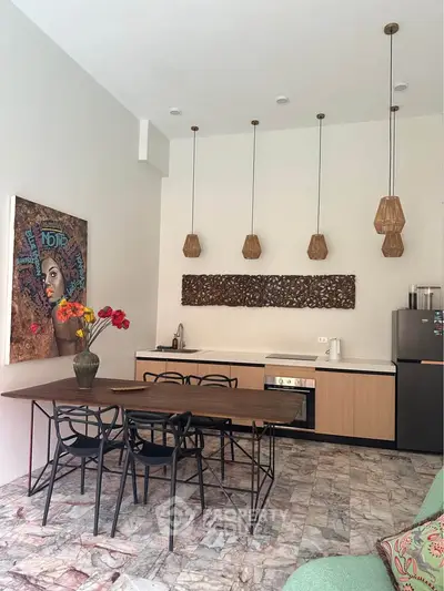 Stylish open-layout kitchen with modern dining area and artistic decor