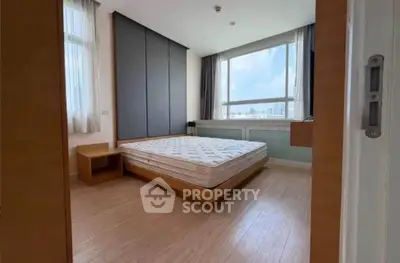 Spacious bedroom with large windows and city view, featuring modern design and ample natural light.