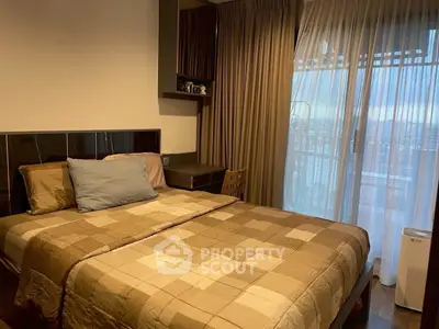 Cozy bedroom with large window and elegant curtains, offering a serene view and ample natural light.