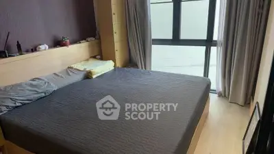 Spacious bedroom with large window and modern furnishings, perfect for relaxation and comfort.