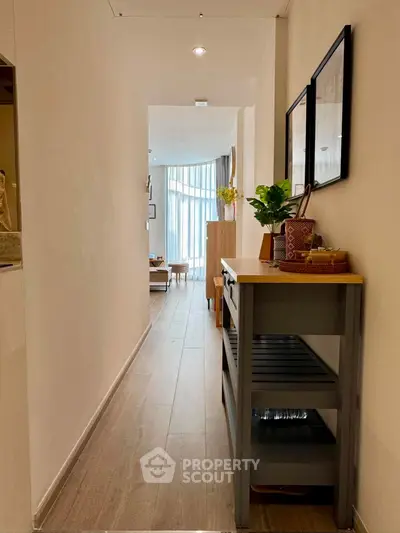 Charming hallway leading to a bright living room with modern decor and natural light.