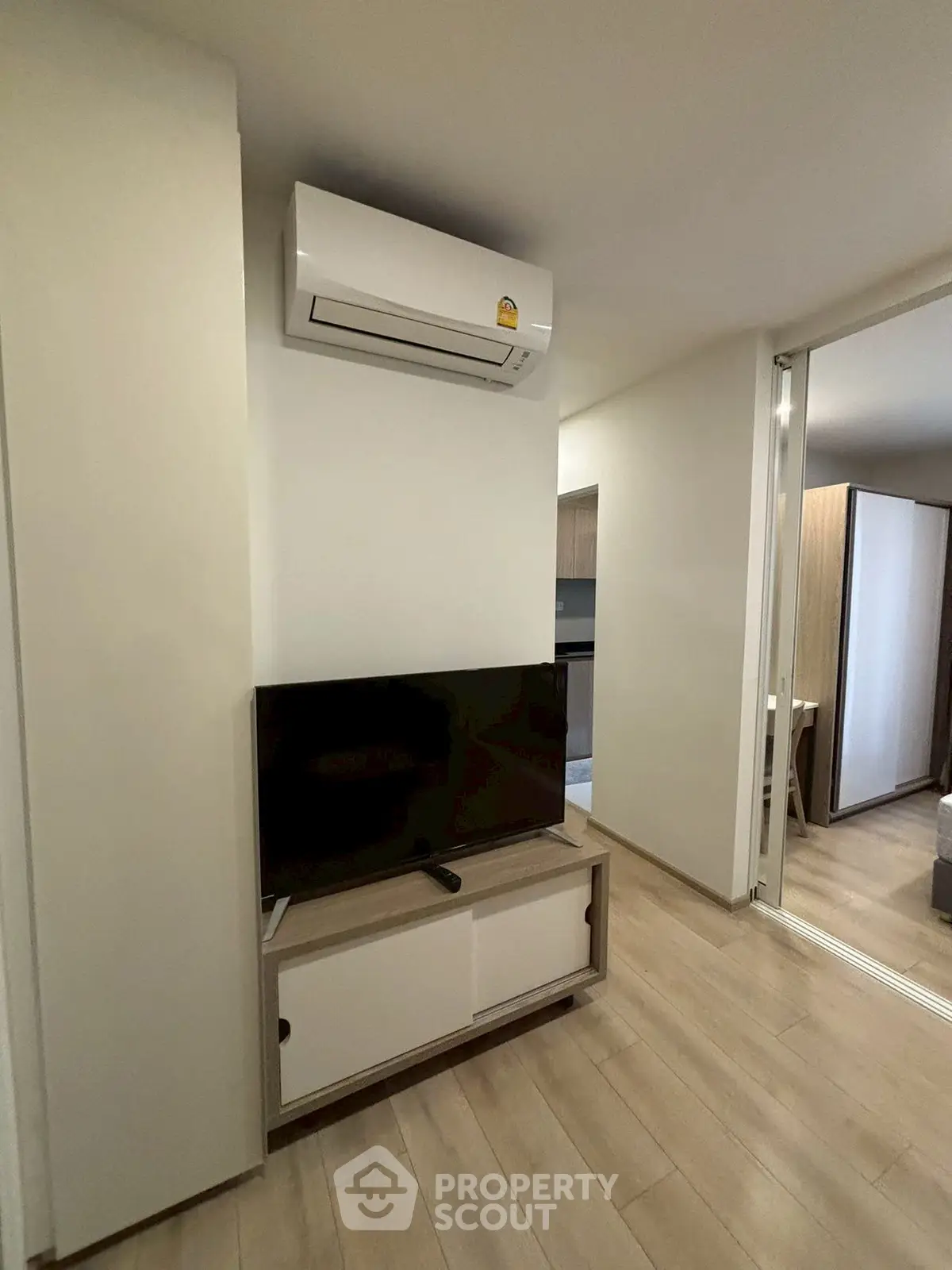 Modern living room with sleek TV setup and air conditioning unit