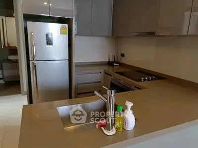 Modern kitchen with sleek countertops and stainless steel appliances in a stylish apartment.