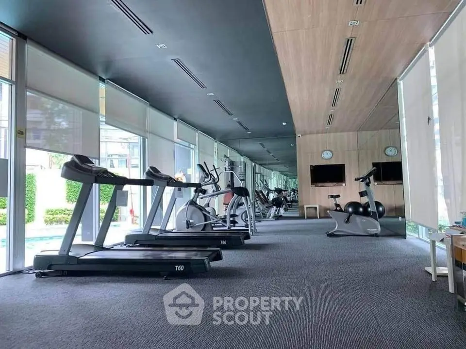 Spacious modern gym with state-of-the-art equipment and mirrored walls in luxury property.