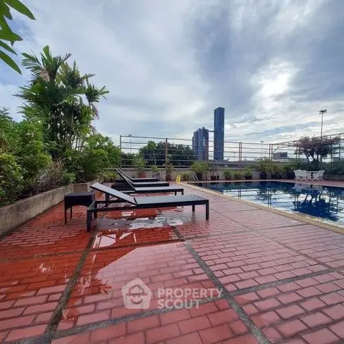 Stunning rooftop pool with city skyline views and relaxing lounge chairs.