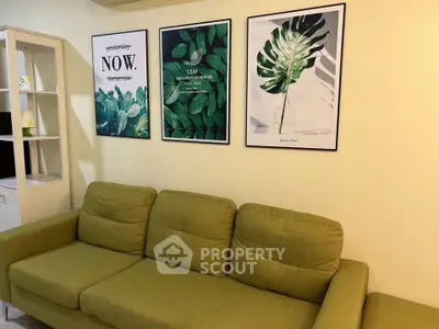 Cozy living room with green sofa and stylish botanical wall art, perfect for relaxation.