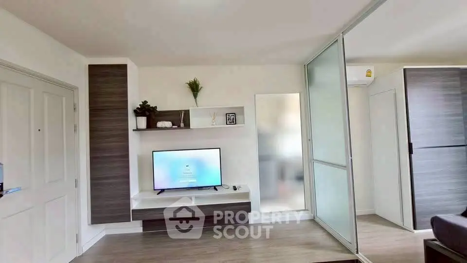 Modern living room with sleek TV setup and sliding glass doors