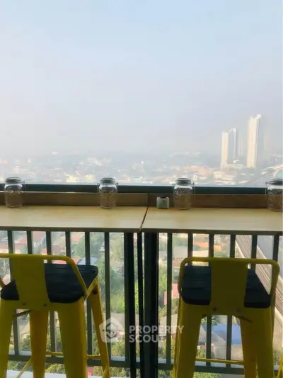 Stunning high-rise balcony view with cityscape and modern seating, perfect for urban living.