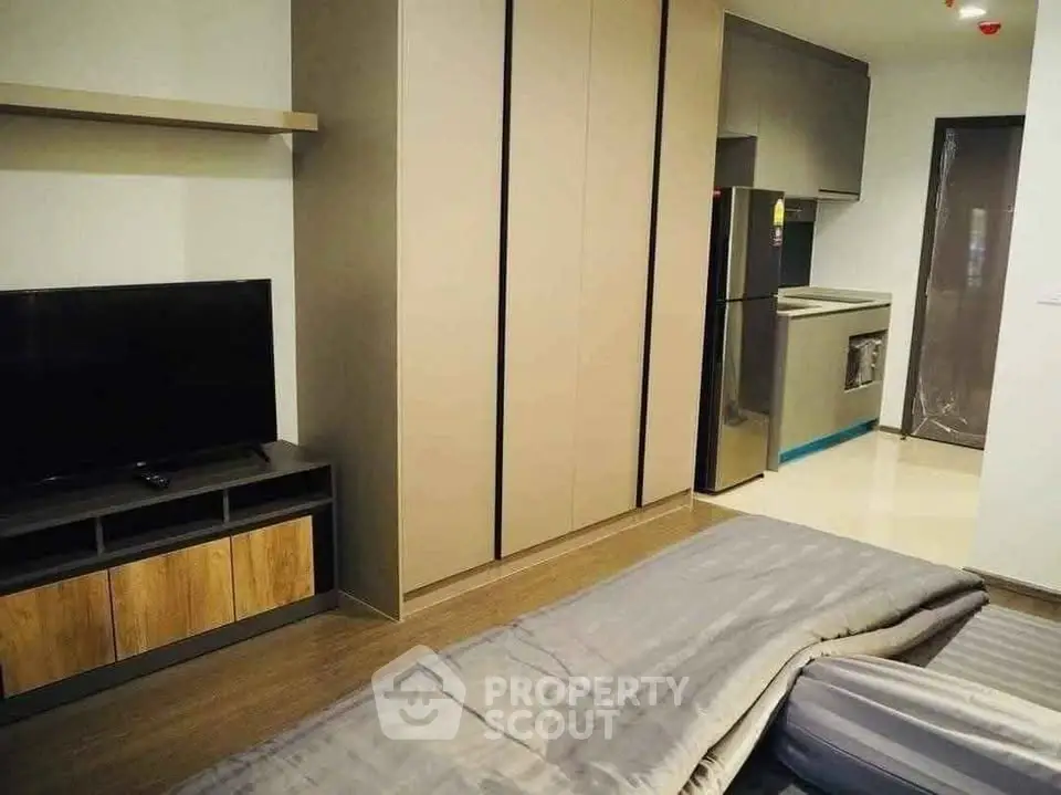 Modern studio apartment with sleek kitchen and cozy living area, perfect for urban living.