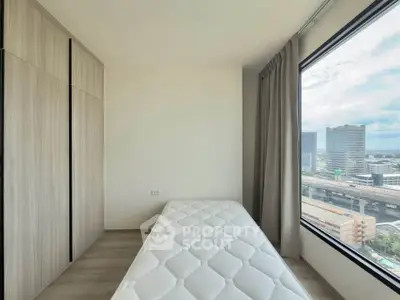Modern bedroom with large window offering stunning city view