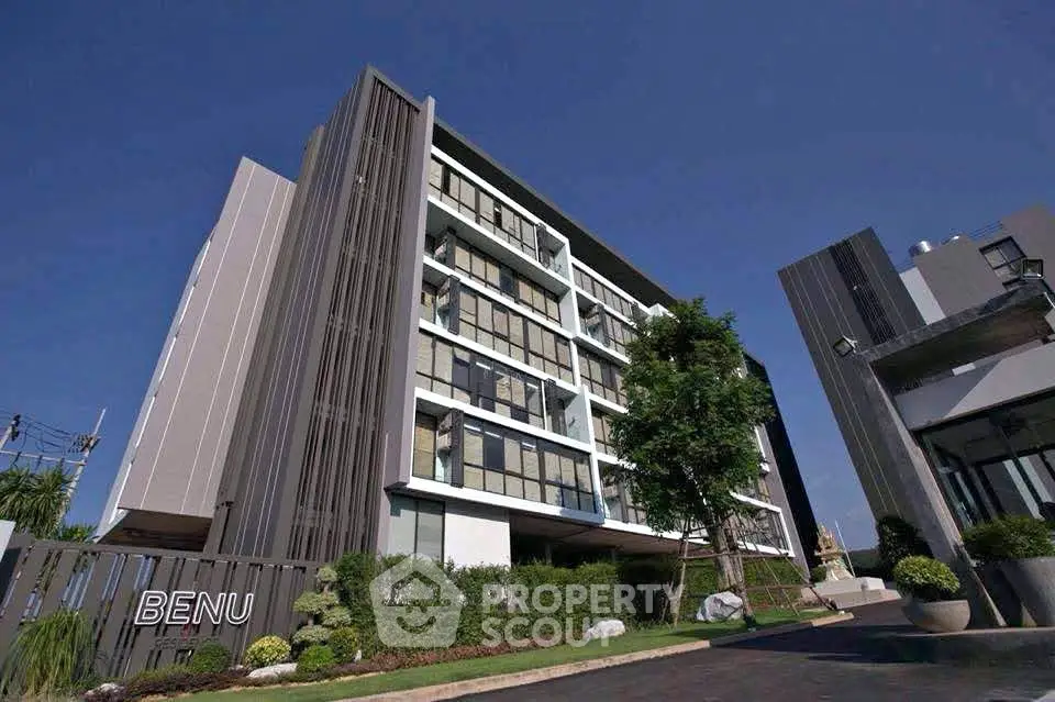 Modern apartment building with sleek design and lush landscaping