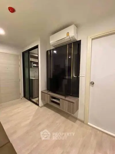 Modern living room with sleek TV unit and air conditioning in a stylish apartment.