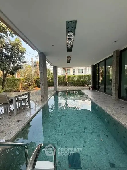 Luxurious indoor pool with modern design and serene garden view