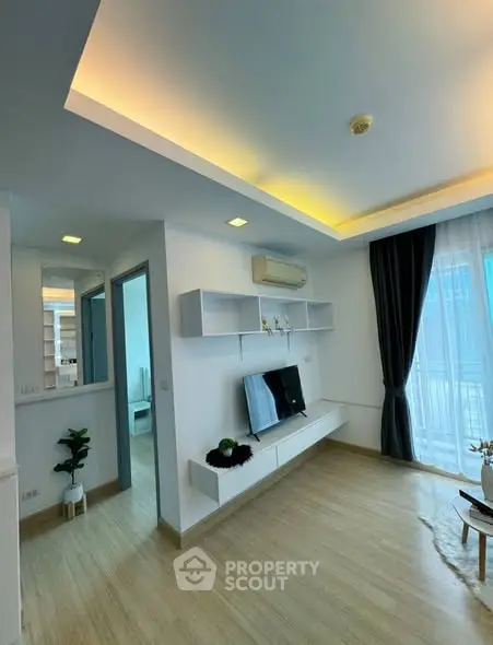 Modern living room with sleek design, featuring built-in shelves and large windows for natural light.