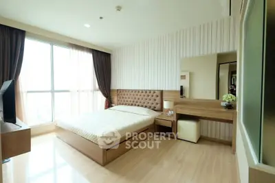 Spacious modern bedroom with large window and elegant furnishings in a high-rise apartment.