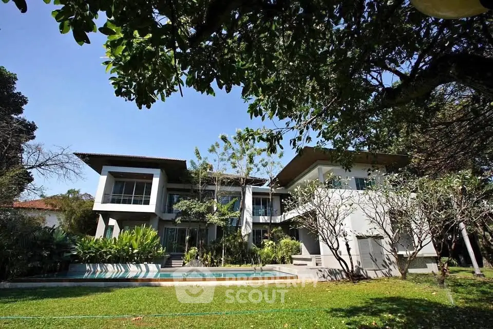 Luxurious modern home with lush garden and private pool, perfect for serene living.