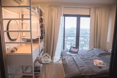 Cozy bedroom with city view, featuring a stylish wardrobe and workspace, perfect for urban living.