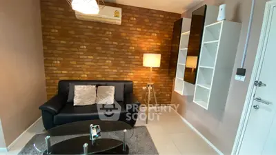 Cozy living room with modern decor, brick accent wall, and stylish furniture.
