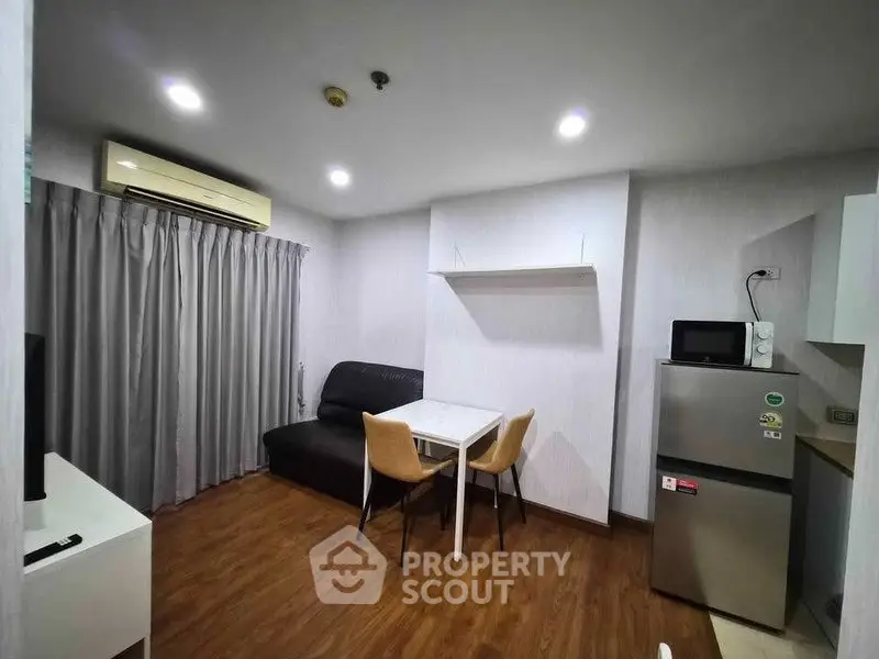 Modern living room with sleek furniture and appliances in a cozy apartment setting.