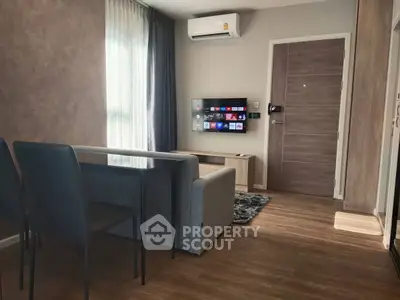 Modern living room with sleek furniture and wall-mounted TV in a cozy apartment.