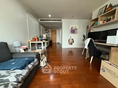 Spacious living room with wooden flooring and modern decor, ideal for comfortable living.