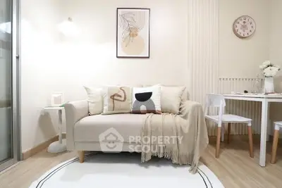 Cozy living room with modern decor and dining area, featuring a stylish sofa and elegant wall art.