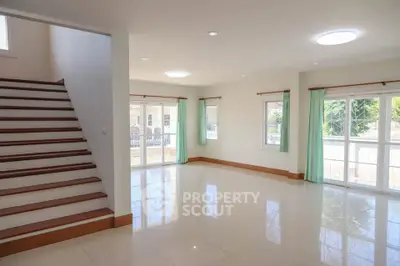 Spacious living room with natural light and staircase in modern home