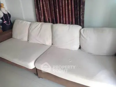 Cozy living room with a comfortable beige sofa and elegant curtains.
