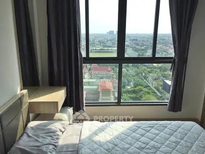 Spacious bedroom with stunning city view from large windows, featuring cozy bed and elegant curtains.
